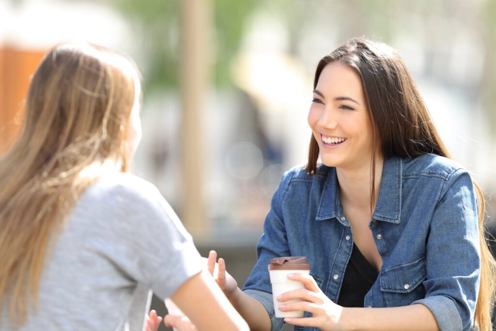 two women drinking coffee and talking